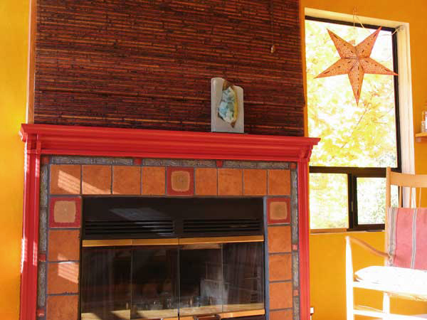 Dramatic tile design and rich gold wall colors ensure the fire always feels like it is lit in this Ballard living room.