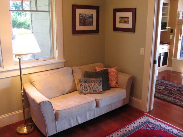 A cozy corner couch in a media room works with soft wall color so the homeowners' collections of rugs and pillows create the "pop" in the room.
